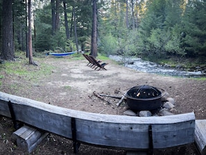 Hammock, firepit, log bench and chairs at the creek