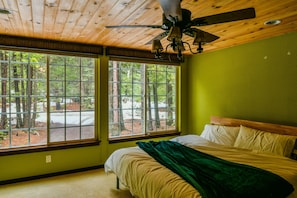 King Bed in the loft bedroom suite with large windows to peer outside into the f