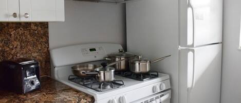 Fully equipped kitchen with a microwave, stove, oven and fridge. All utensils, plates and glasses are provided