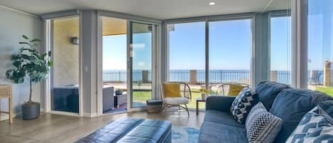 Bright and airy living space with floor-to-ceiling windows offering a panoramic view of the Pacific