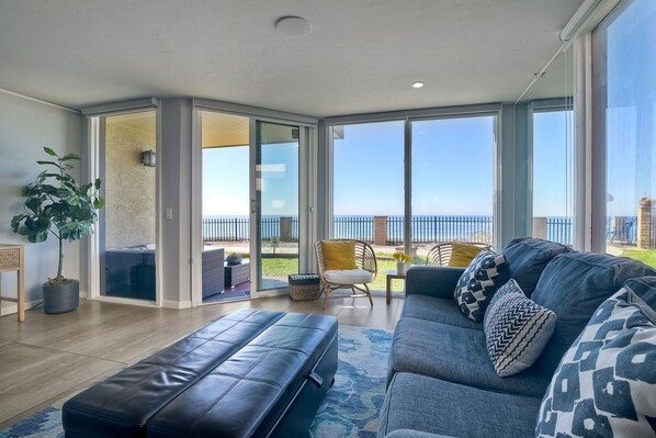 Bright and airy living space with floor-to-ceiling windows offering a panoramic view of the Pacific