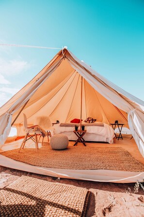 A look inside one of our King tents which includes 1 King bed. We offer multiple tent arrangements - King, Twin, Triple and Family! 
Note: furniture, décor and bed configuration may differ between tents.