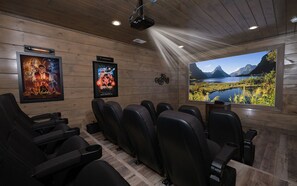 Private Theater Room with Projector Screen and Theater Seating