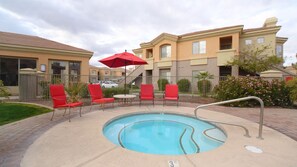 Hot tub next to heated pool with seating area