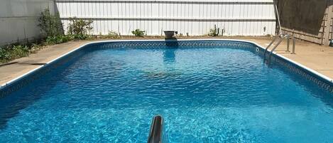 In-ground swimming pool with diving board in the deep end.