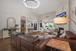 Large Living room with gas fire place large screen tv over looking the pool/lake