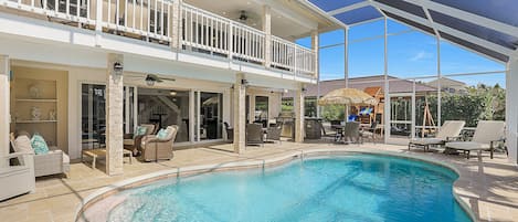 Pool view showing second floor Lanai, 1 floor seating area and outdoor kitchen