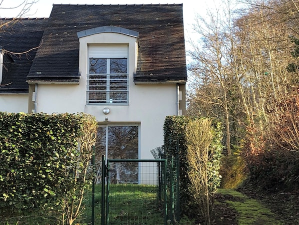 Baie vitrée donnant sur un petit jardin clos situé plein sud.