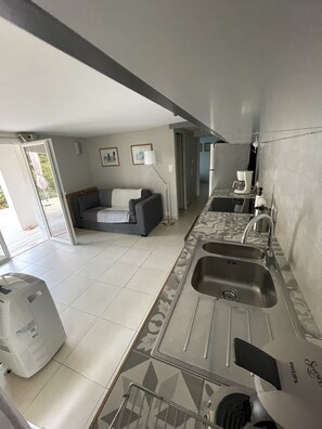 Vue séjour : plan de travail cuisine long 3 m, divan convertible 140x200, clim.
