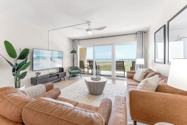 A cozy yet modern living area with plush leather seating, floor-to-ceiling windows, and an incredible ocean view.