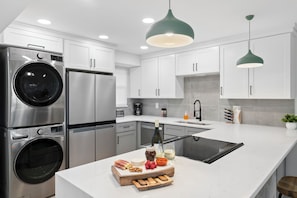 Stylish all-white kitchen with high-end appliances, and a convenient in-unit washer and dryer.