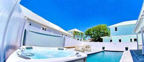 Hot tub and pool with large pool deck and outdoor seating