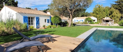 Vue générale sur une des terrasses, la piscine, la grande et la petite maison