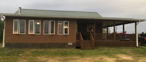 Front view of the cabin showcasing our sun room and wide wraparound deck.