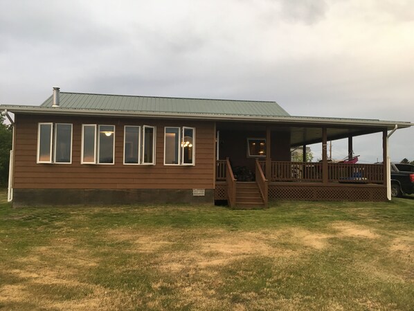 Front view of the cabin showcasing our sun room and wide wraparound deck.