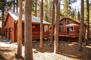 A detached two-car garage sits in front of the cabin.