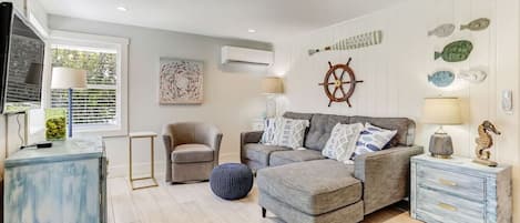 This spacious living room features plenty of comfortable seating, a cable TV with stream capabilities, a laptop table to make working from the beach a breeze, and lots of natural lighting.