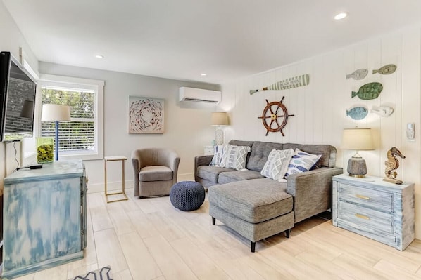 This spacious living room features plenty of comfortable seating, a cable TV with stream capabilities, a laptop table to make working from the beach a breeze, and lots of natural lighting.