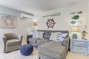 This spacious living room features plenty of comfortable seating, a cable TV with stream capabilities, a laptop table to make working from the beach a breeze, and lots of natural lighting.