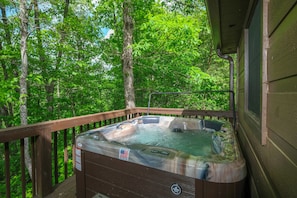 Hot tub on the private back deck overlooking the wooded lot.