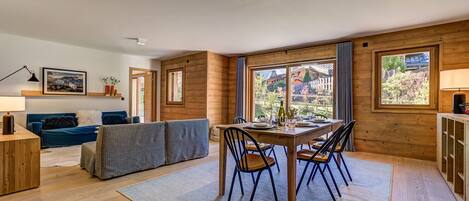 Dining table sits in front of large glass doors