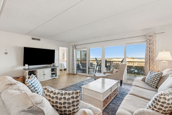 Beautiful Living Space with Magnificent Ocean and Pool Views, a Large Flat Screen Smart TV, and a Slider to the Terrace