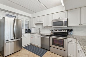 Luxury Fully Equipped Kitchen with Stainless Steel Appliances, Stunning Granite Counters, and A Decorative Subway Tiled Backsplash