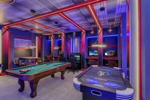 Exciting game room of the home in Kissimmee Florida - A variety of classic and modern games to suit all tastes - A haven for gamers and enthusiasts alike to indulge their passions - Pool, Air hockey and consoles games