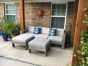 Patio seating under the pergola and garden lights at night.