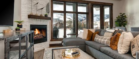 Professionally decorated Living Room with 55" Samsung smart tv, gas fireplace, large sectional sofa with sleeper, and breathtaking views of the Canyons Golf Course and Resort
