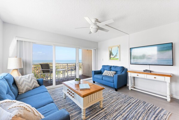 The living room greets you with floor-to-ceiling ocean views, where the salty breeze drifts through sunlit space.