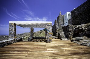 The large deck area at one end of the swimming pool and the shaded area