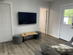 Living room with sleeper sofa, door to private back deck and yard