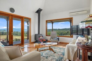 Spacious living area with a wood heater and AC/heat pump