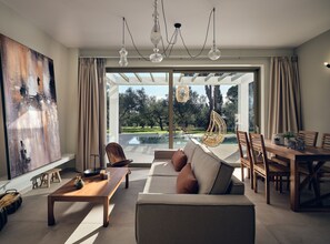 The open plan living room enjoys sweeping pool views & iconic design. 