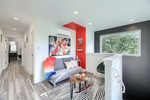 Cozy Living Space With Modern Art, Vibrant Color Accents, And A Comfortable Sofa Bed