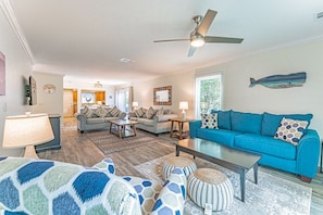 Large Living Room space with three couches, chair and 70” television