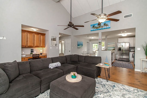 Spacious open floor plan with large sectional couch, high ceilings, Roku TV