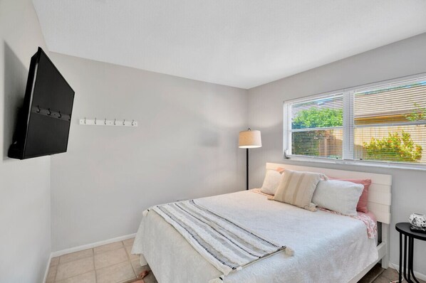 Bedroom with queen bed, hybrid cooling gel memory foam mattress, and smart TV.