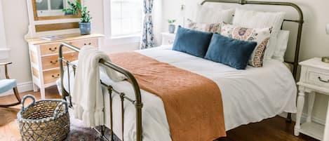 Bedroom with queen-size bed, dresser, & closet. 