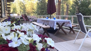 Wide Front Deck Looks out Over the Paver Fire Patio and Flower Beds