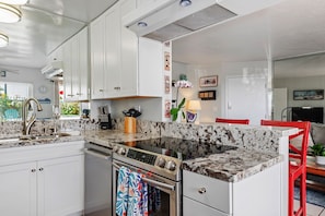 Kitchen facing living room with serving area for guests.
