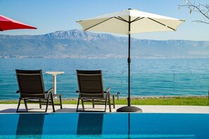 Deck chairs by the pool of Croatian private luxury vacation villa for rent and vacation at the beach on Ciovo