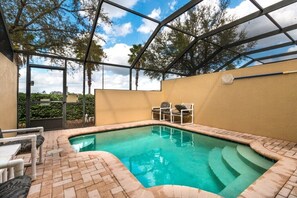 Private screened-in pool with patio seating – ideal for sunbathing or outdoor dining.