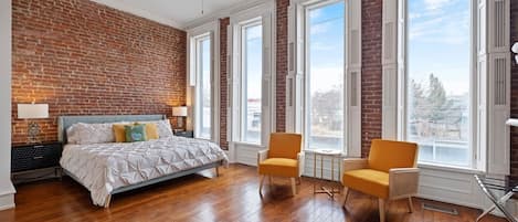 OMG. Massive King Suite with Floor to Ceiling picture windows, exposed brick, original hardwoods, sitting area and cozy fireplace. 