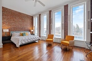 OMG. Massive King Suite with Floor to Ceiling picture windows, exposed brick, original hardwoods, sitting area and cozy fireplace. 