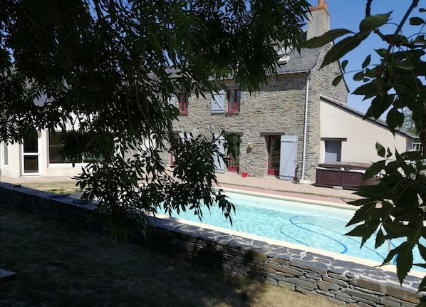 Vue du jardin sur la façade , cuisine , chambre à l'etage .