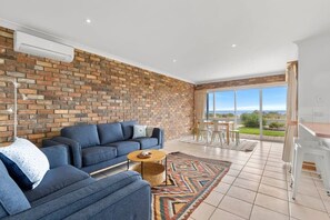 The self-contained ground floor living, dining and kitchenette has bay views