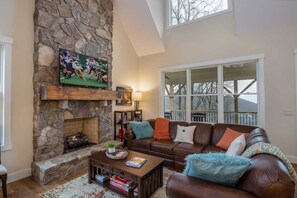 Comfortable Leather Sectional Situated around the Floor-to-Ceiling Stone Fireplace and HDTV in the Main Living Area