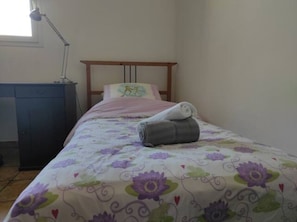 Lit simple dans la grande chambre exposée EST